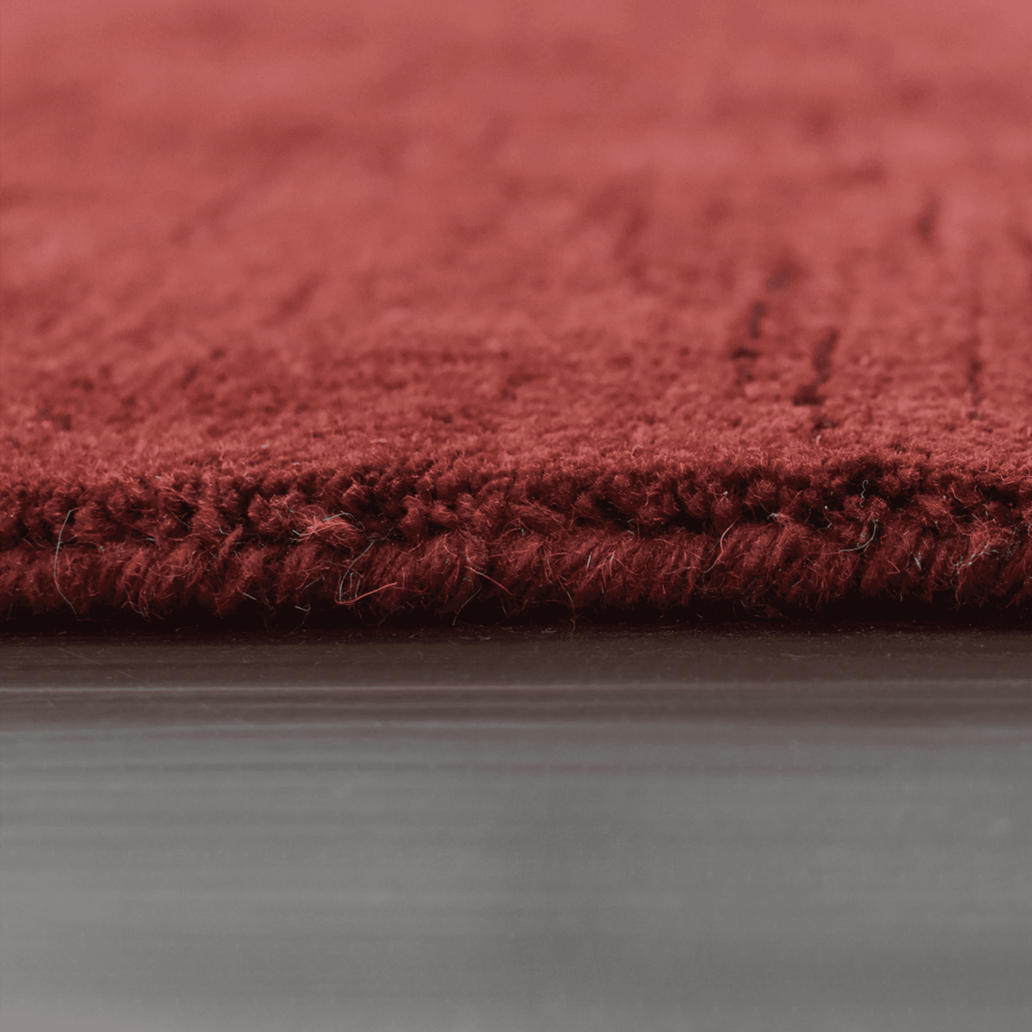 Red rug edge with short dense pile and tightly bound border close-up