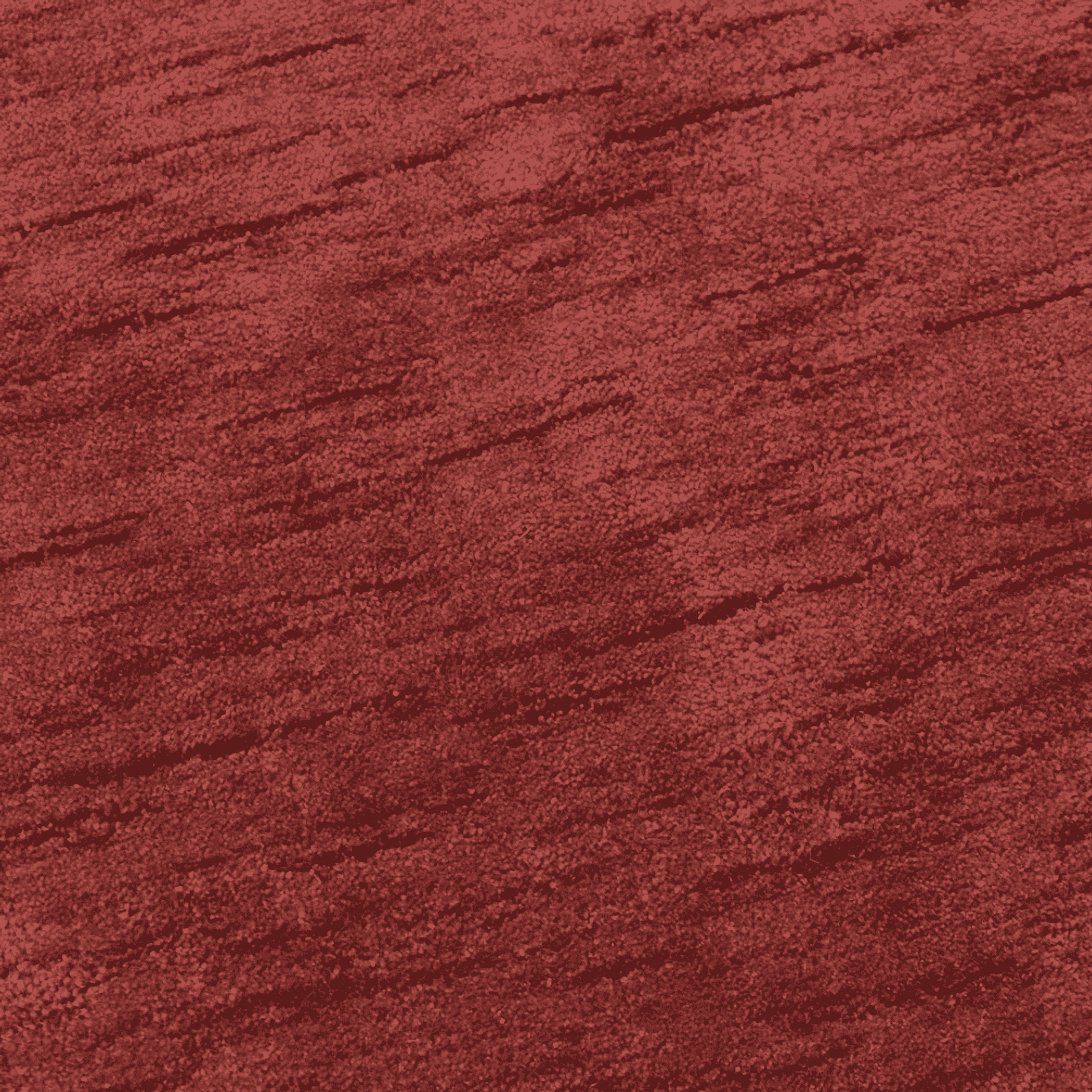 Red rug surface with dense short pile and subtle lines, close-up