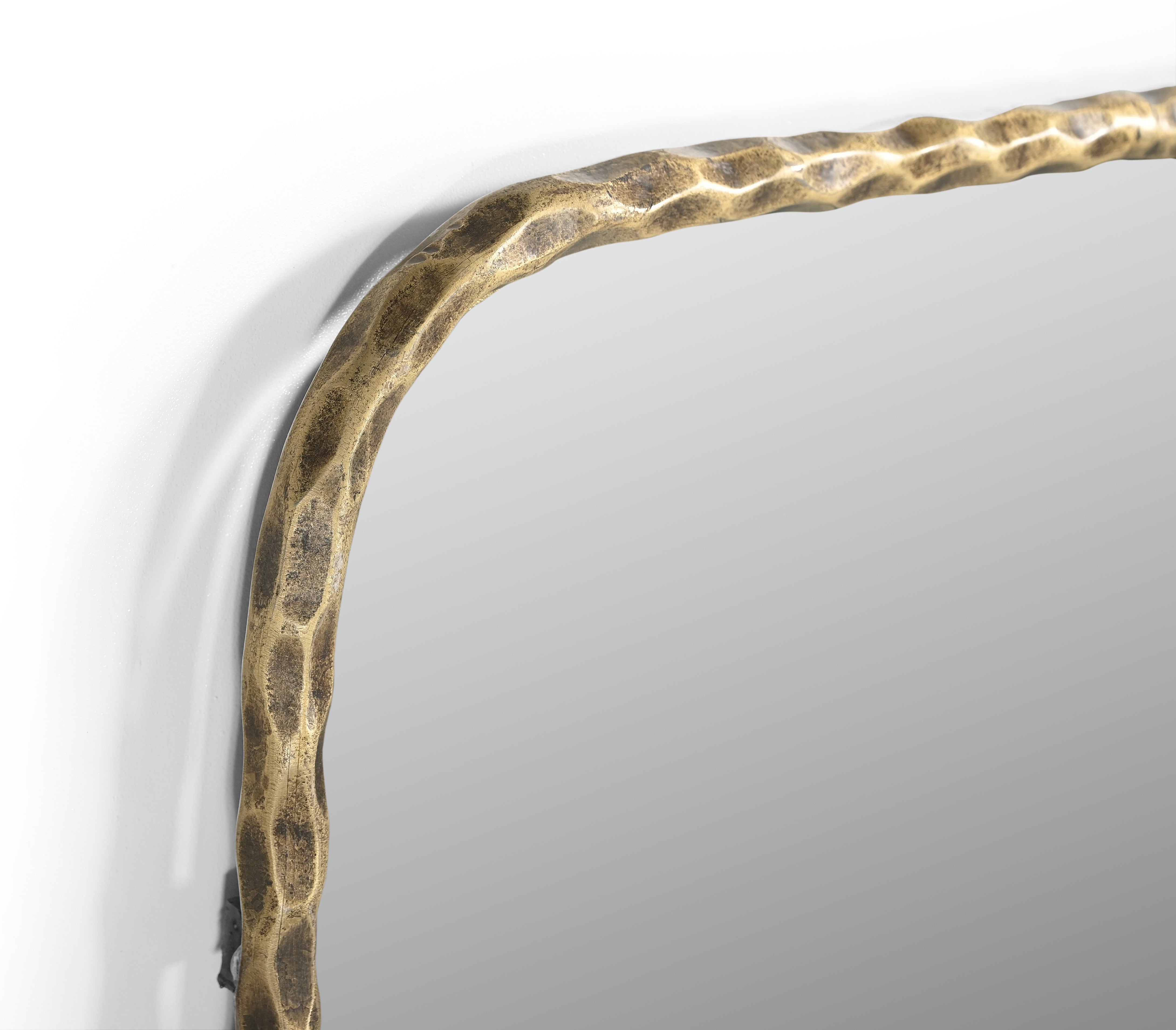 Hammered gold-tone brass iron frame corner detail on rectangular mirror