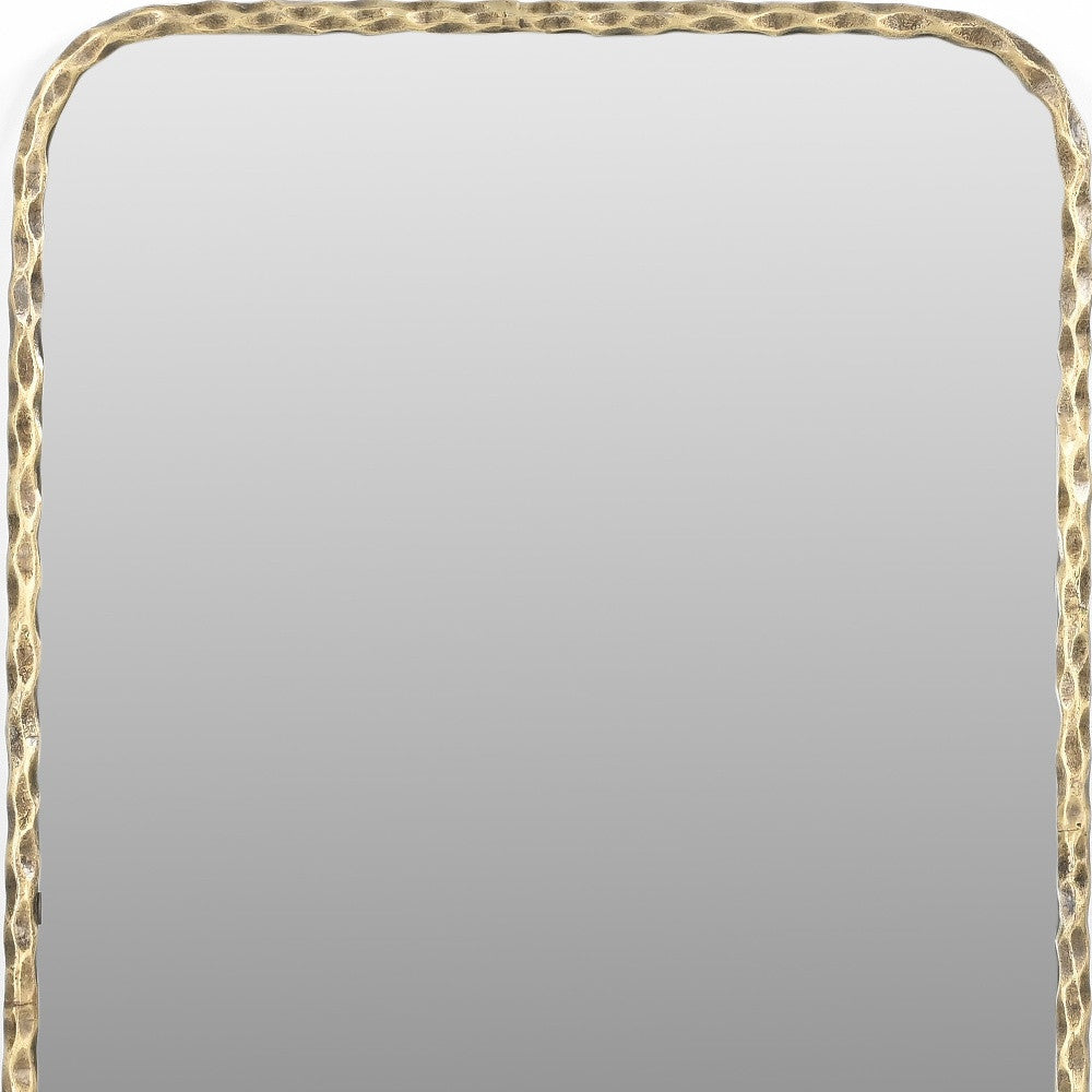 Hammered gold-tone brass mirror frame edge with scalloped texture