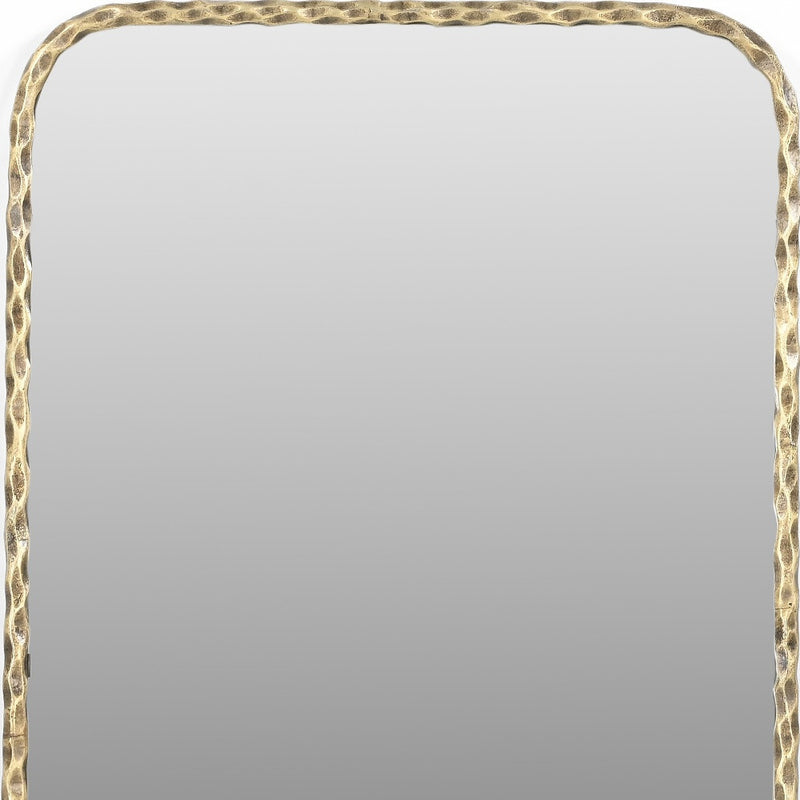 Hammered gold-tone brass mirror frame edge with scalloped texture