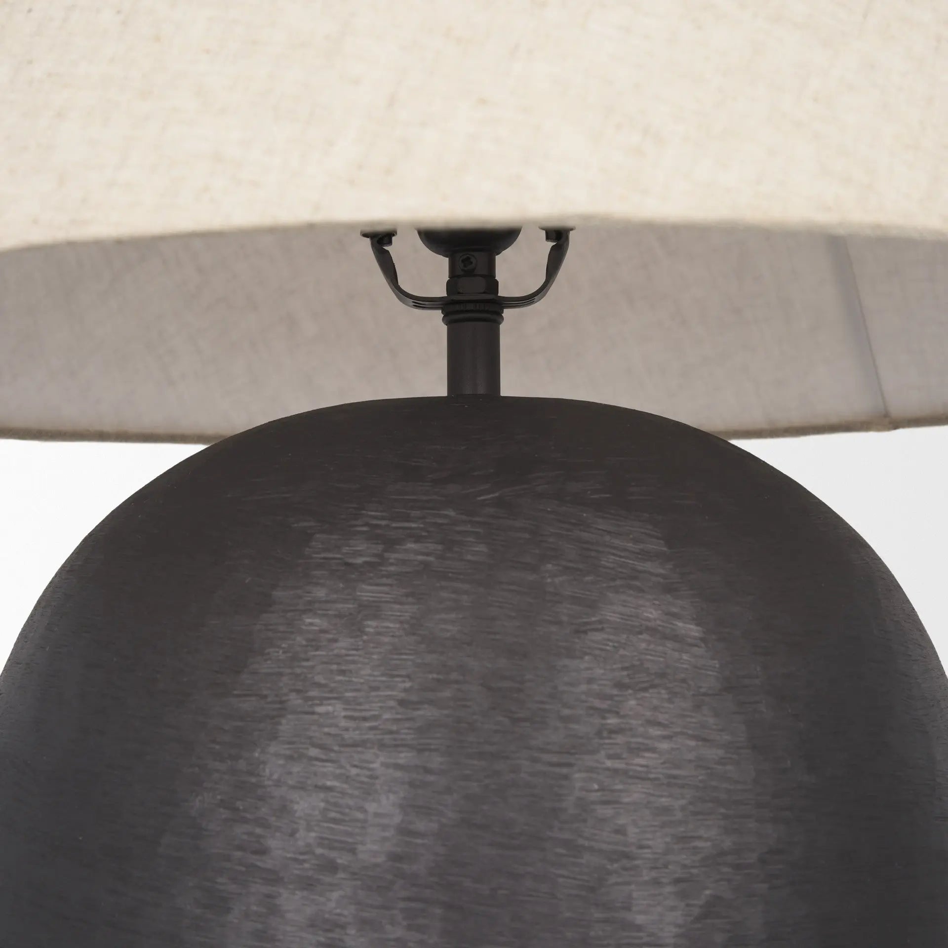 Modern black ceramic table lamp with a textured finish and a cream linen shade, perfect for contemporary decor.
