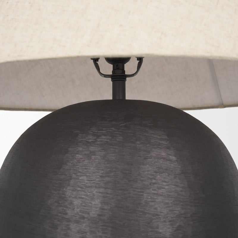 Modern black ceramic table lamp with a textured finish and a cream linen shade, perfect for contemporary decor.