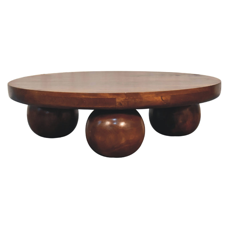 Chestnut round coffee table with three sculpted leg forms and smooth circular top.