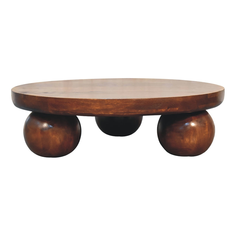 Round chestnut wood coffee table with curved legs and dark underframe supports.