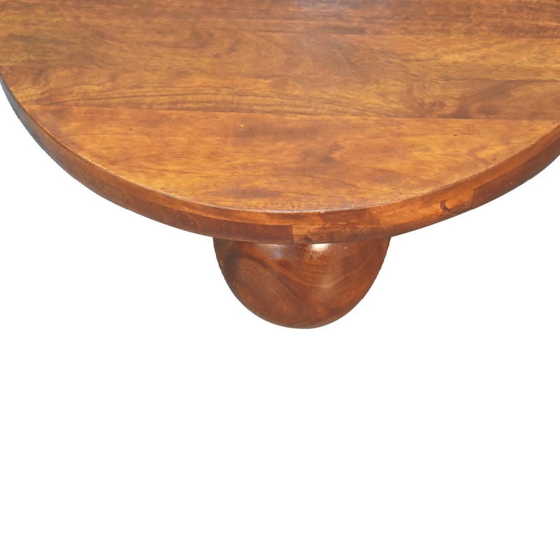 Round chestnut wood coffee table with tapered pedestal base beneath the tabletop.