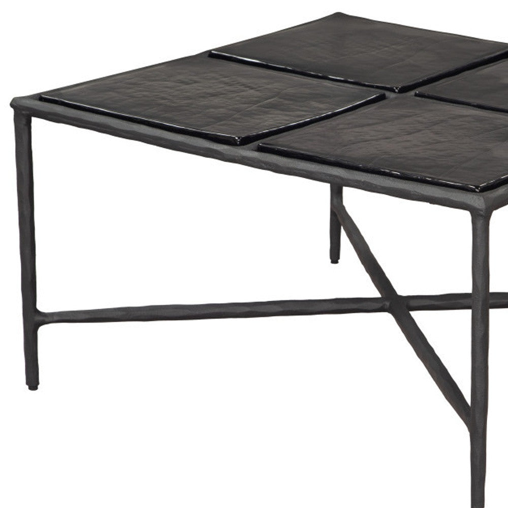 Black square glass coffee table with aluminum frame and four-panel glass top, angled view