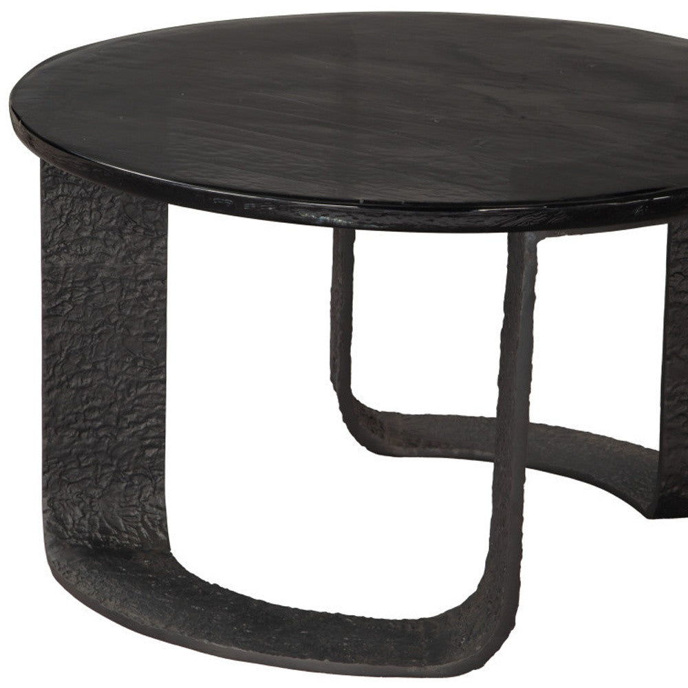 Black round pedestal coffee table with textured base and side profile legs