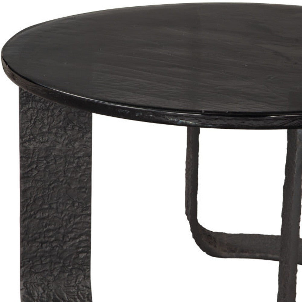 Close-up of black round coffee table top edge and textured pedestal base