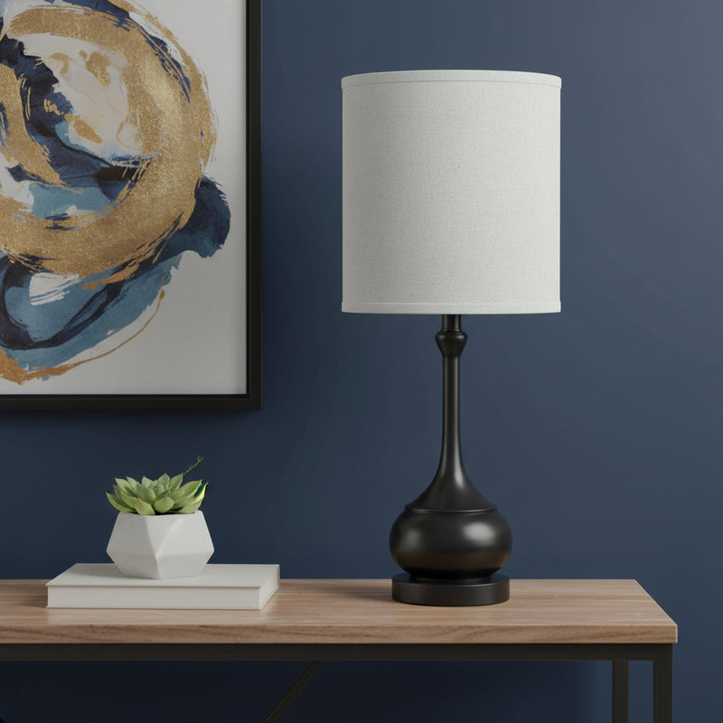 Blackened bronze table lamp with off-white drum shade and round base