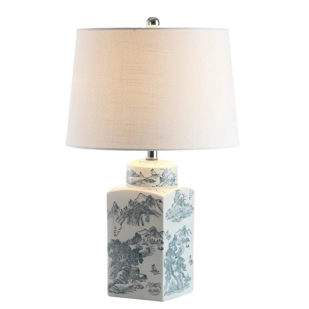Blue and white porcelain lamp with a scenic design and a white textured shade, perfect for elegant decor.