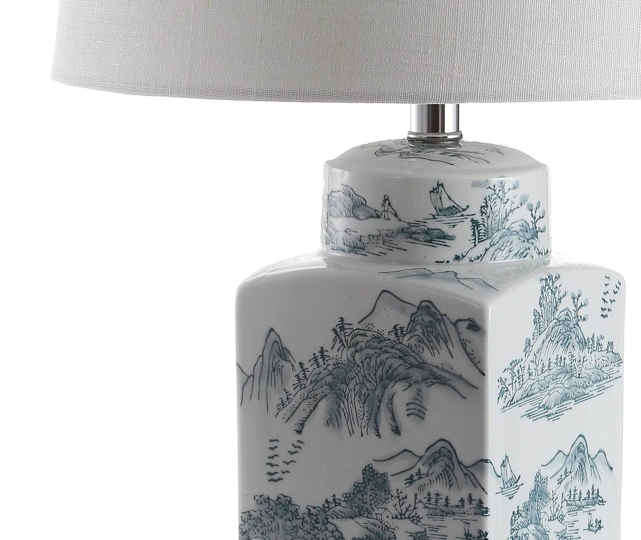 Blue and white porcelain lamp with intricate landscape design, topped with a classic white fabric shade.