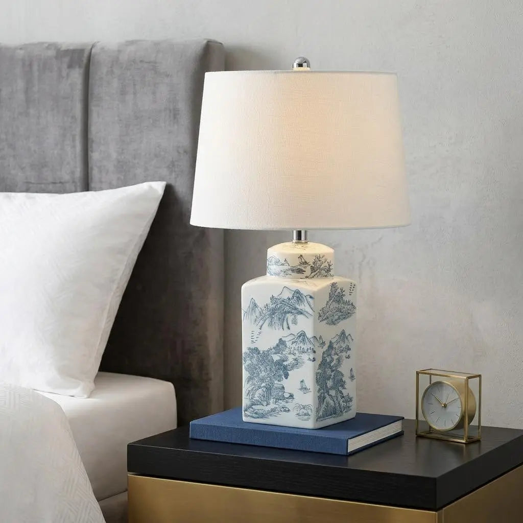 Blue and white ceramic table lamp with a fabric shade, ideal for modern bedside decor.