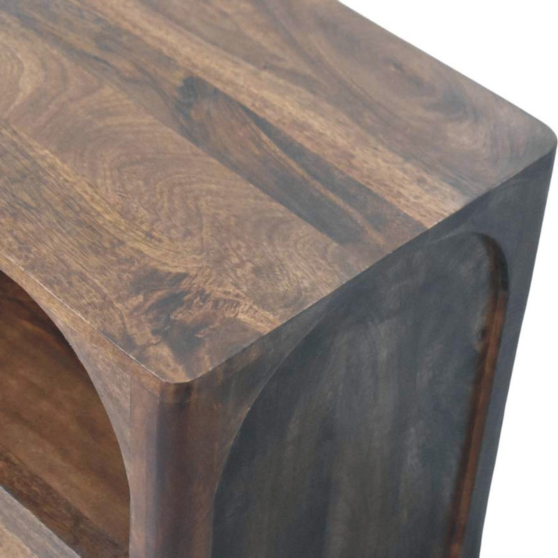 Brown solid wood nightstand angled close-up showing arched shelf and side panel.