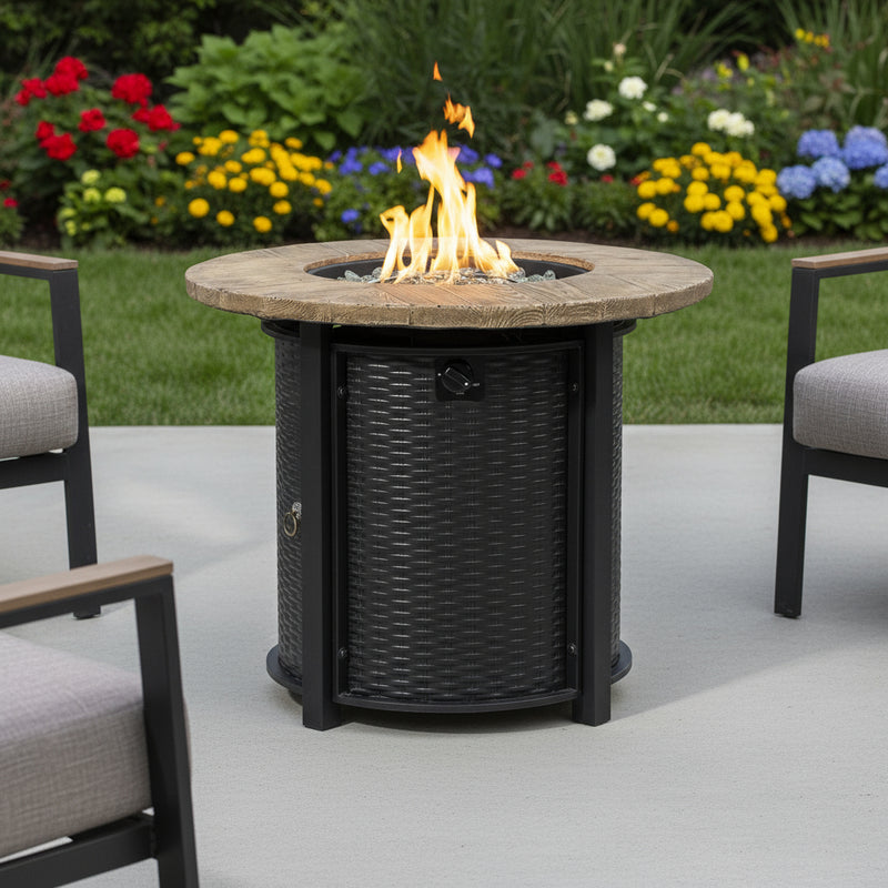 Round propane fire pit with tall flames, black base, and woven gray sides