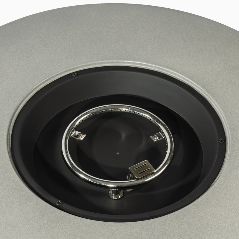 Close-up of round fire pit burner cover opening with chrome ring and black interior
