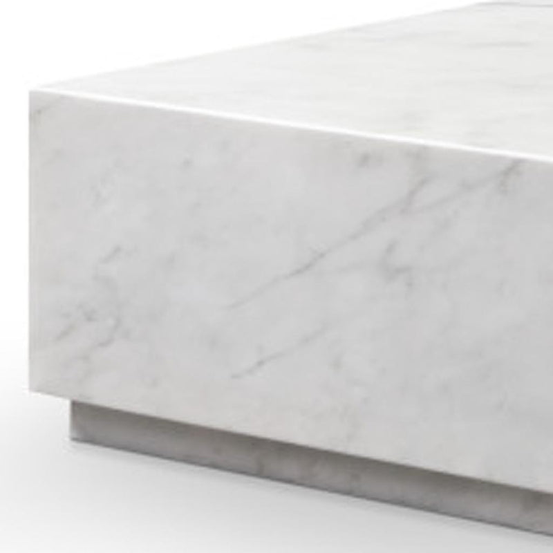White marble block coffee table side view with gray veining and flat top