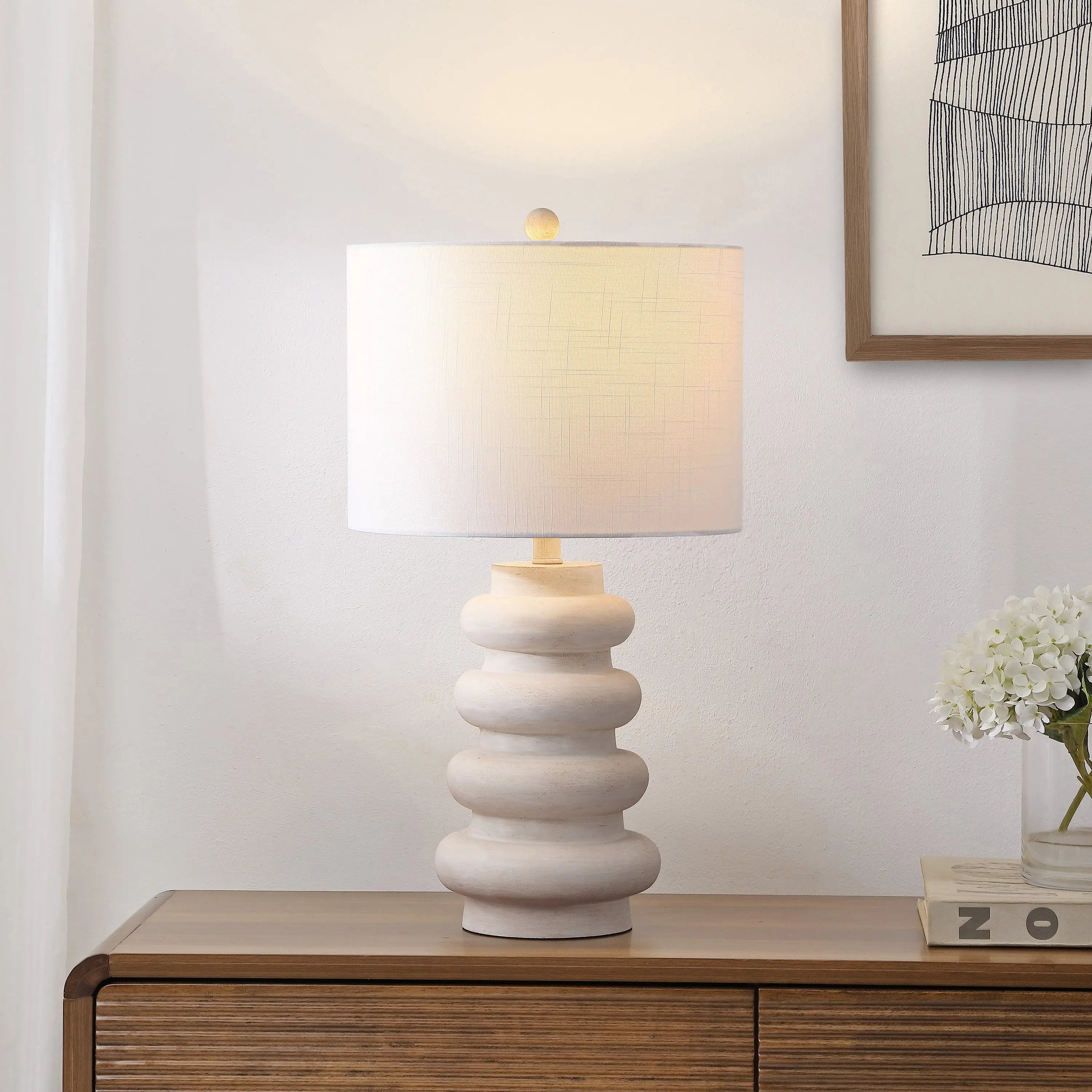 Modern white ceramic table lamp with textured stacked design and a drum shade, perfect for contemporary decor.