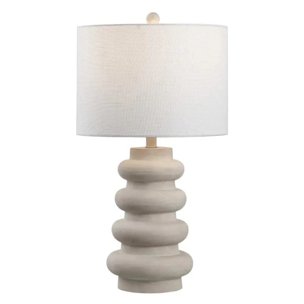 Modern cream ceramic table lamp with a textured circular base and a white fabric shade. Ideal for contemporary decor.