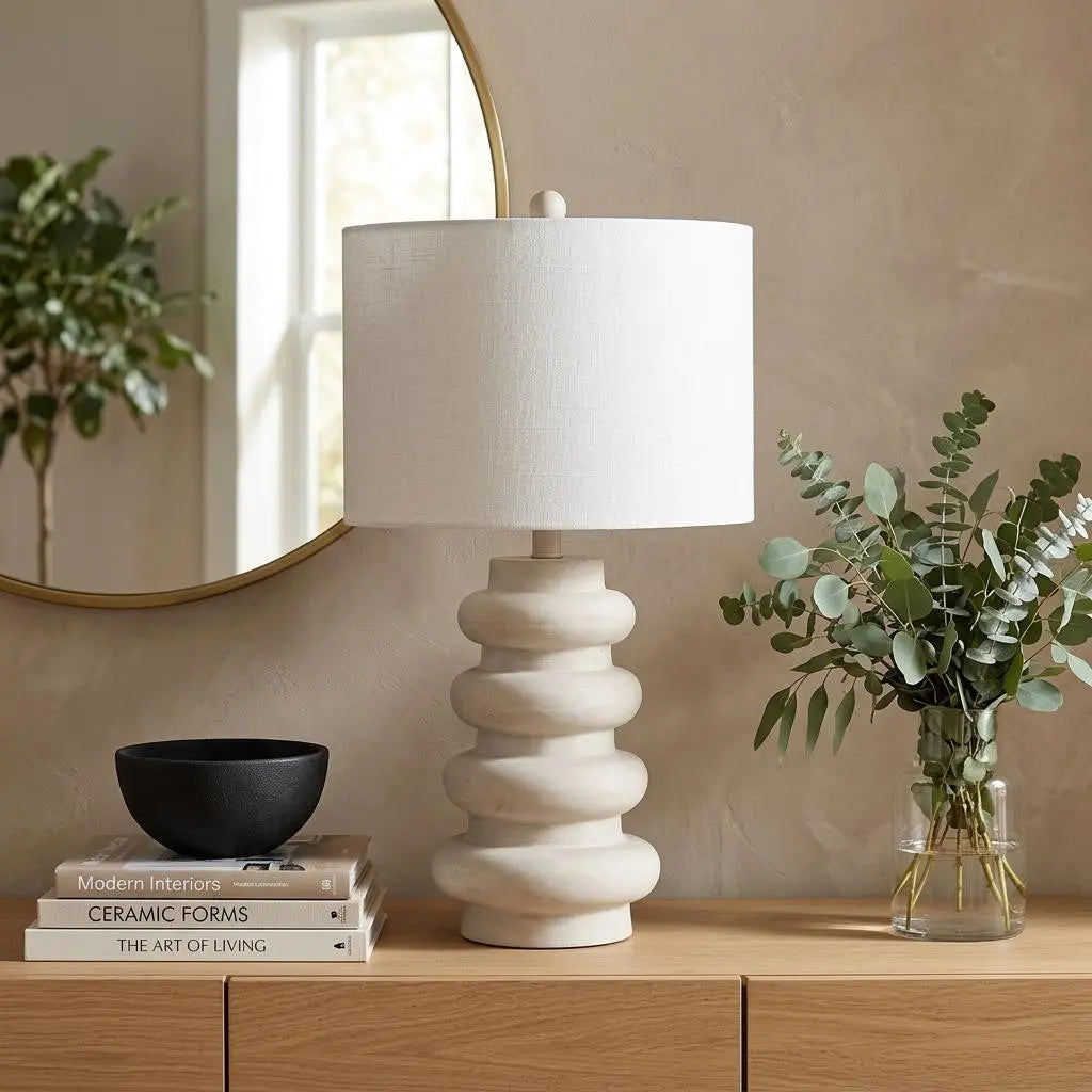 Light beige ceramic lamp with a textured base, white linen shade, and modern design, perfect for contemporary decor.
