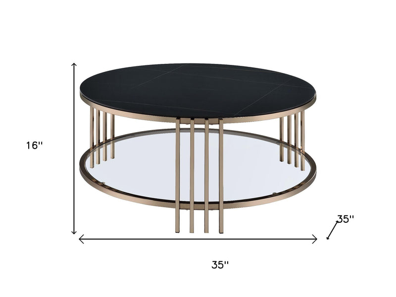 Round coffee table with black top, champagne legs, and metal base ring; 35 in wide.