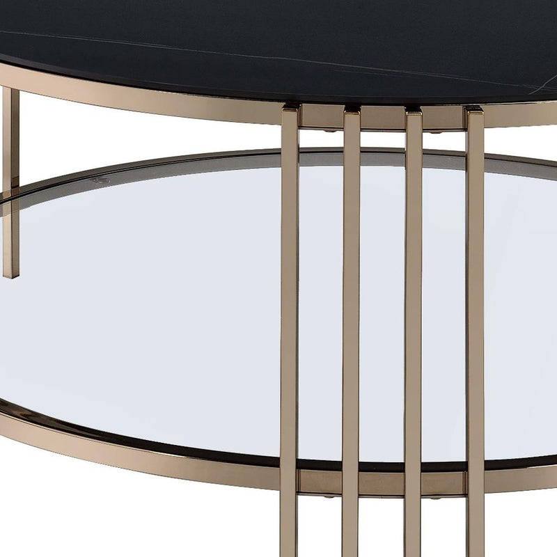 Close-up of black tabletop edge and champagne metal supports under round coffee table.
