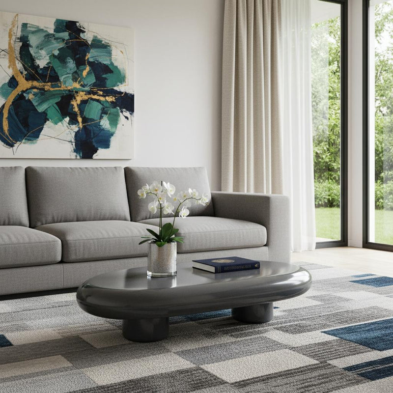 Gray oval coffee table with smooth tabletop and three dark round support legs