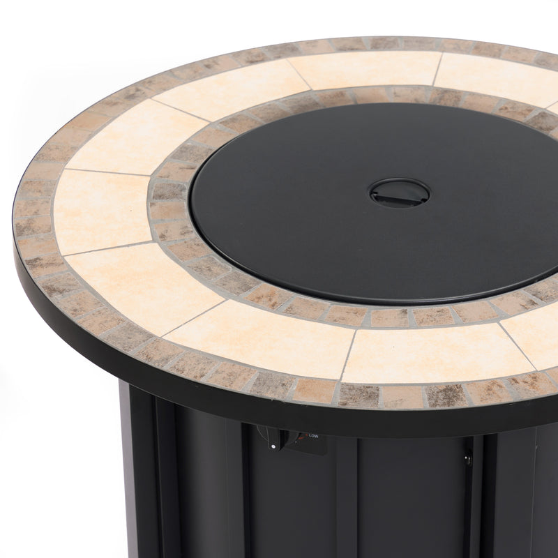Black fire pit with round dark lid and beige stone surround in patio setting