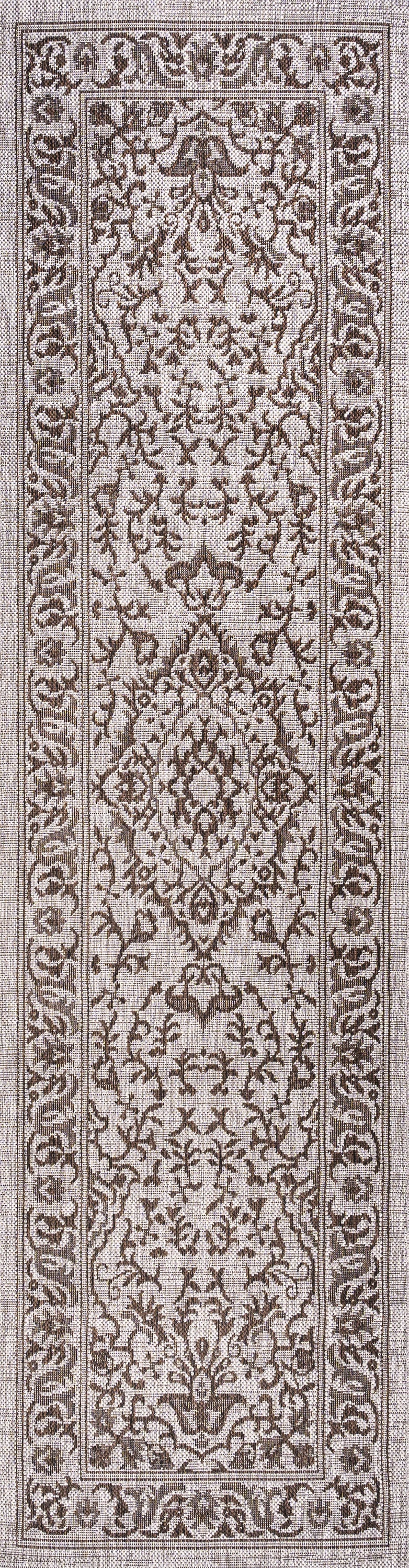 Medallion runner rug close-up with ornate brown and beige vine details.
