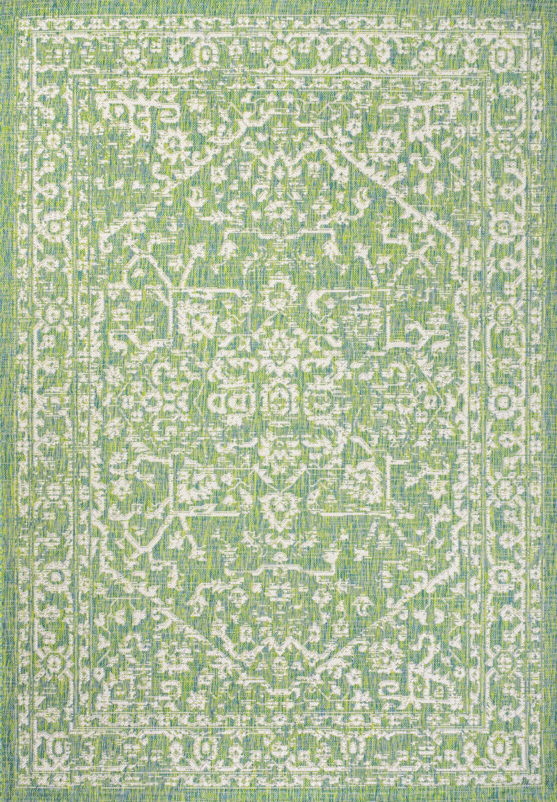 Cream and green medallion area rug close-up of dense geometric lattice pattern.