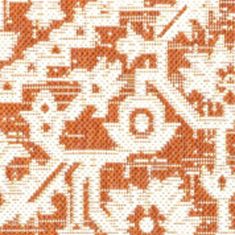 Close-up of orange and cream patterned rug fibers with geometric motifs