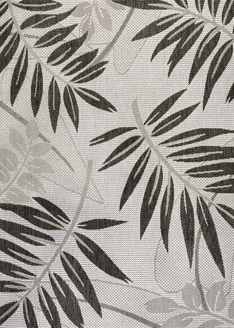 Light background area rug with dense black and gray leaf floral pattern