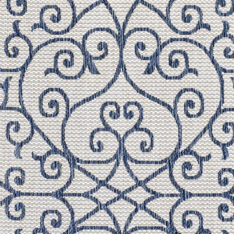 Geometric area rug close-up of cream fabric with blue swirls and diamond lattice
