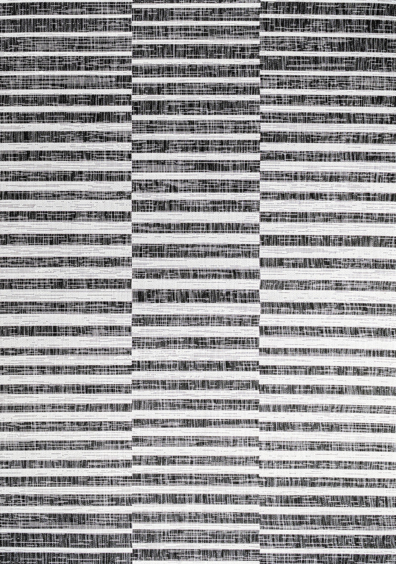 Close-up of black and ivory striped area rug with alternating horizontal woven bands.