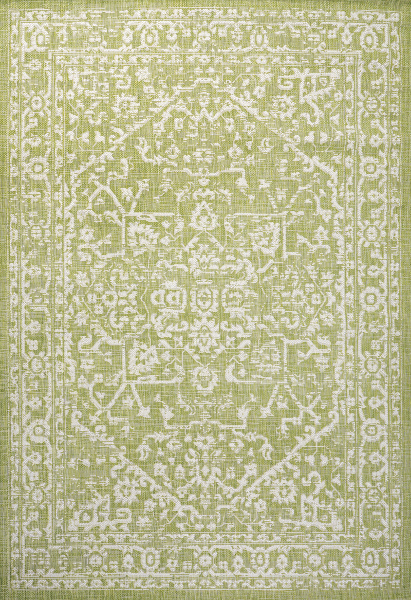 Green and cream medallion rug close-up with distressed geometric motifs