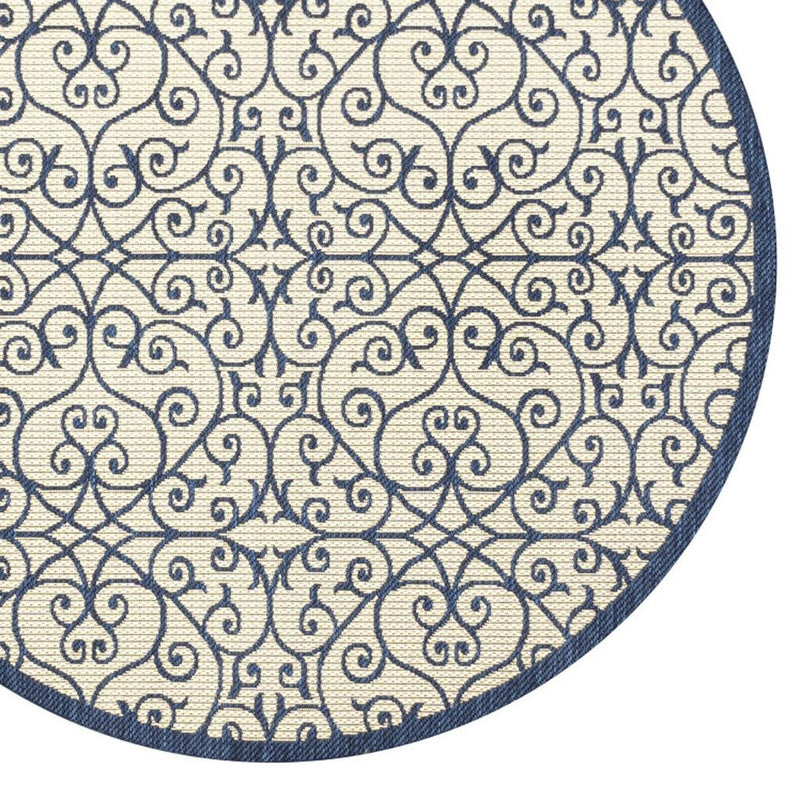 Top view of round rug showing navy ornate scroll and lattice pattern