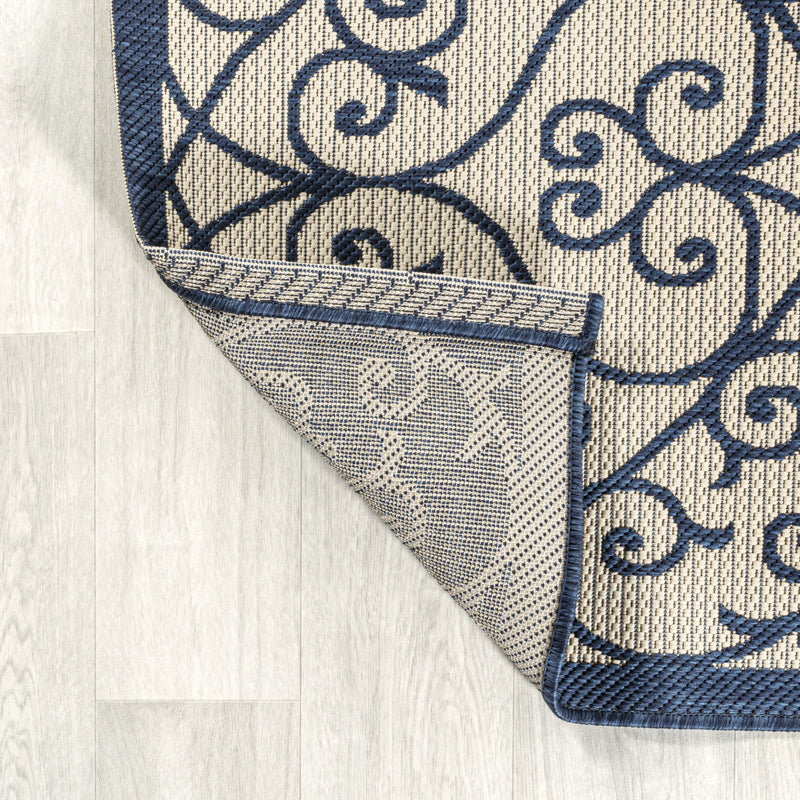 Rug edge corner with navy border stitching and beige fabric texture