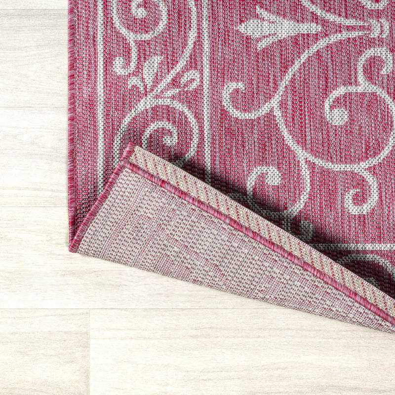Fuchsia runner rug corner close-up with light gray scrolls and patterned trim