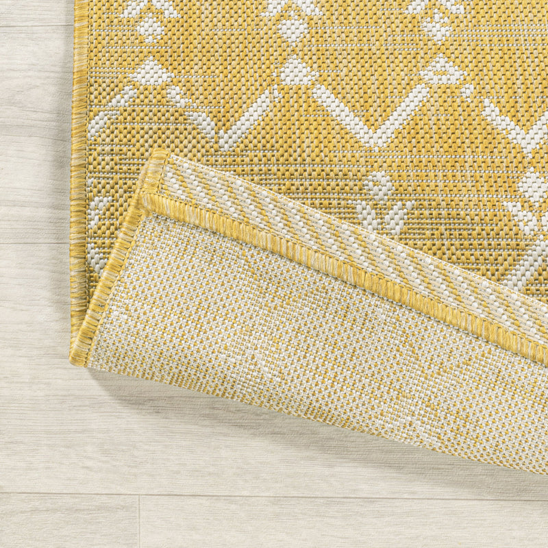 Yellow and cream trellis rug close-up with stitched border and woven texture
