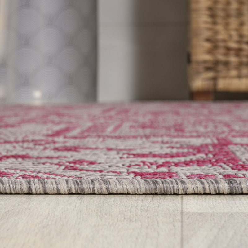 Low-profile light gray and fuchsia patterned rug with stitched border trim