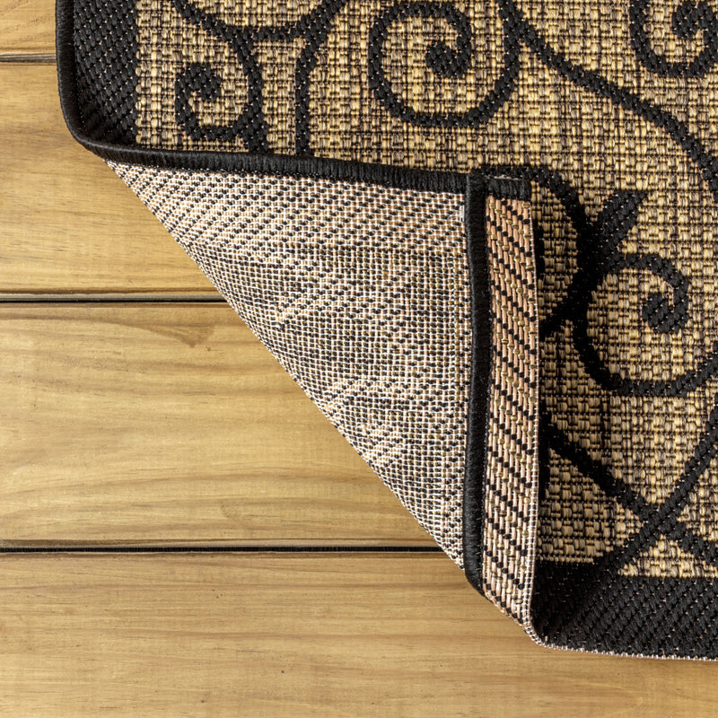 Rug corner showing khaki woven face and dark black border trim