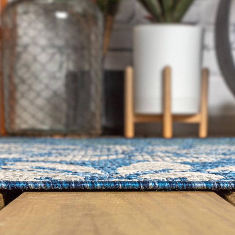 Rug edge with flat woven pile and blue stitched border
