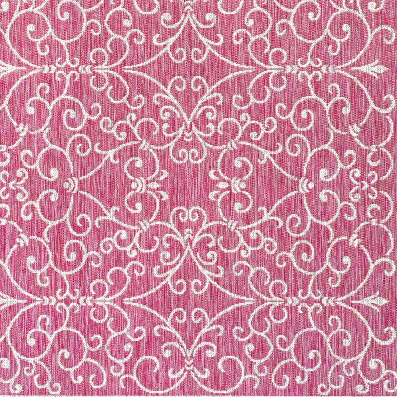Close-up of fuchsia area rug with light gray ornate floral swirl pattern