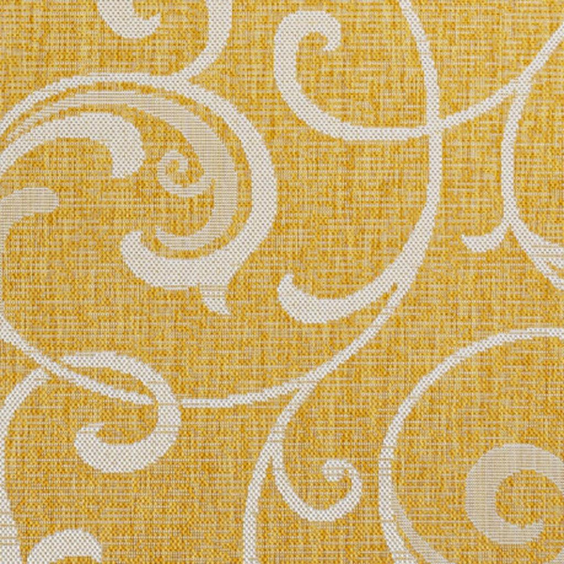 Yellow rug with cream ornate vine scroll pattern, close-up