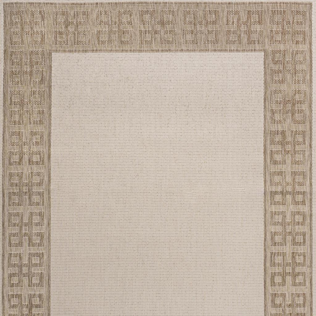 Cream area rug close-up with Greek key border and micro-textured center