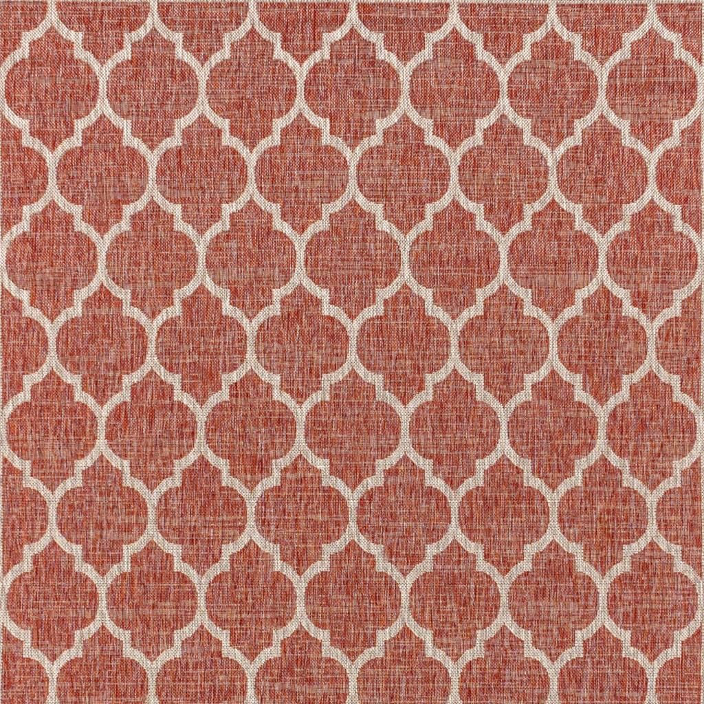 Red and beige geometric rug with repeating trellis quatrefoil pattern