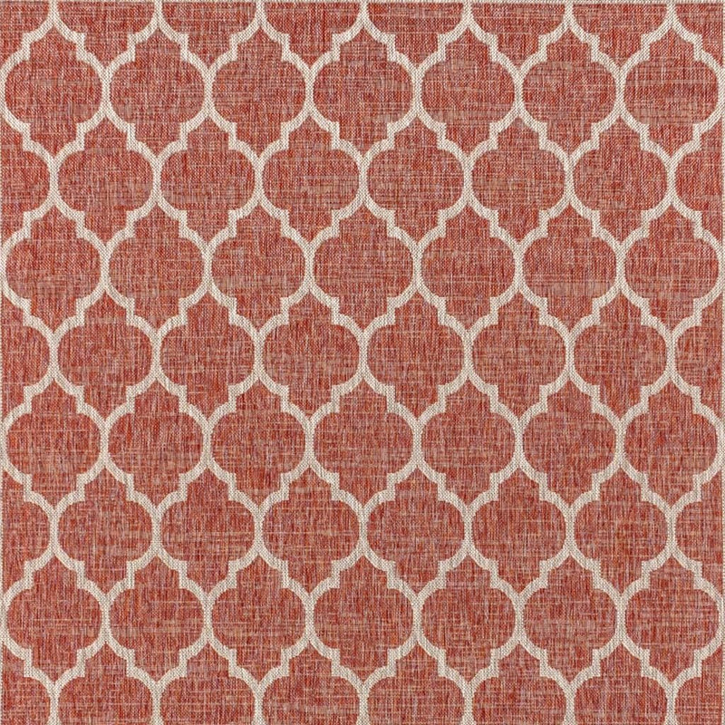 Red and beige geometric rug with repeating trellis quatrefoil pattern