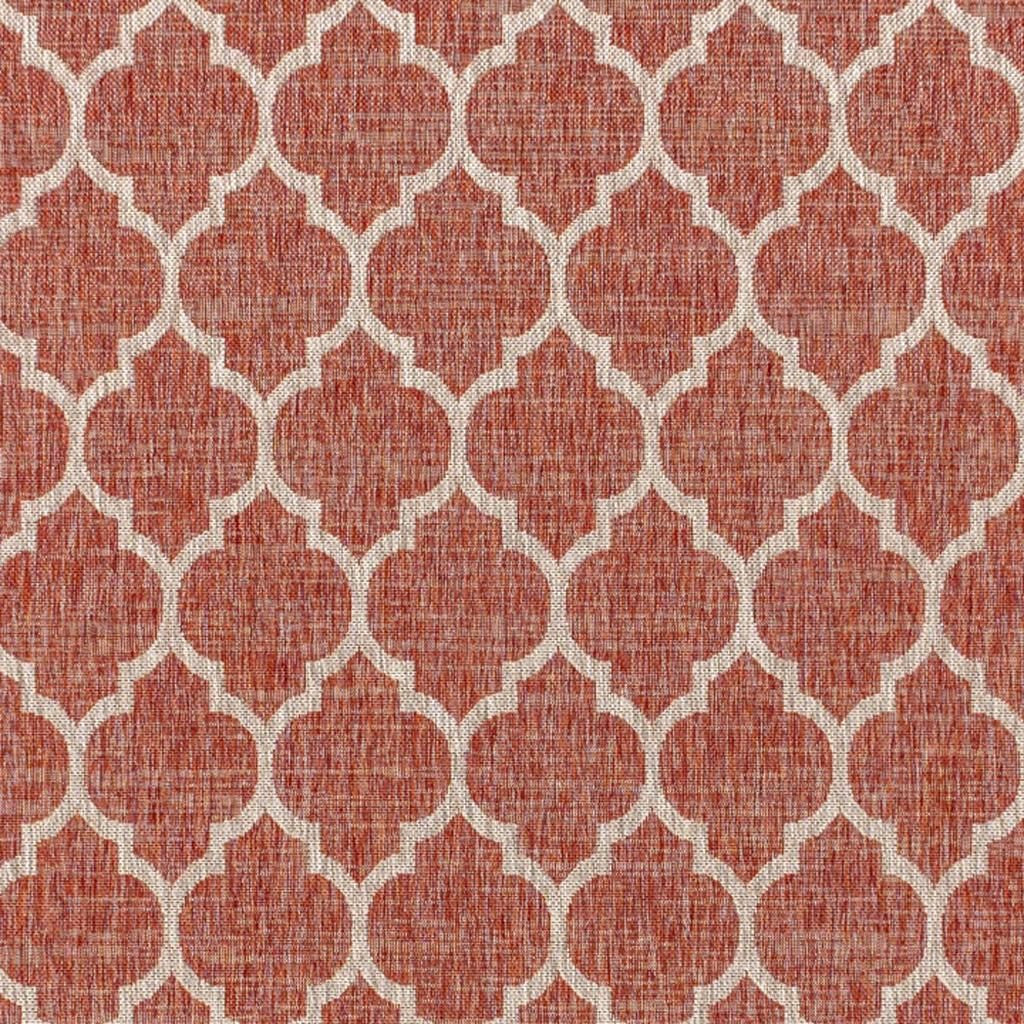 Close-up of red and beige geometric rug with repeating trellis lattice pattern