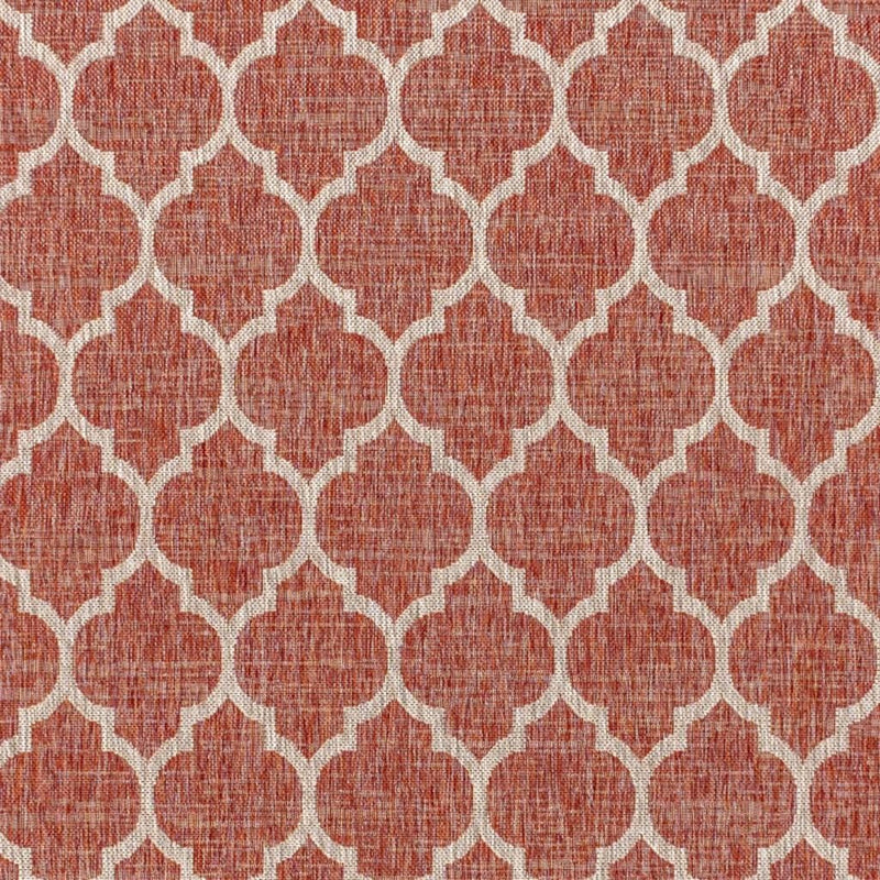 Close-up of red and beige geometric rug with repeating trellis lattice pattern