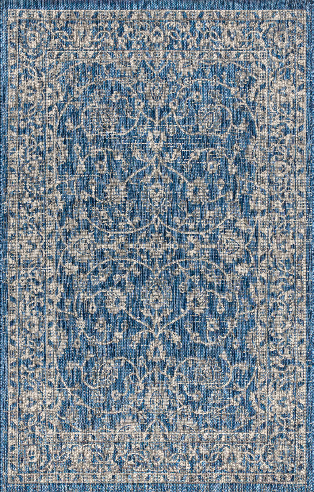 Blue and white medallion area rug with ornate scrolling pattern, close-up